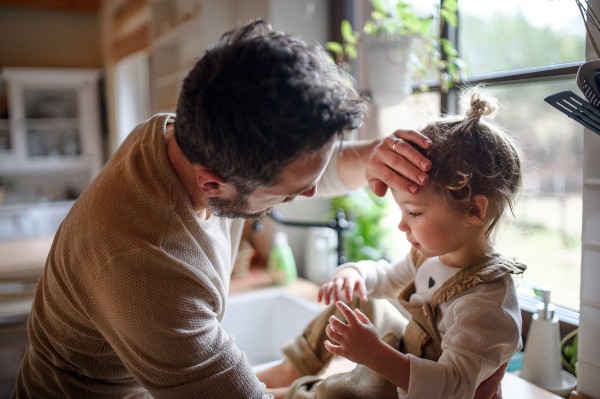 Papà misura la febbre a sua figlia toccando la fronte